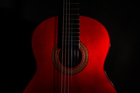 spanish classical red guitar close-up on a black background