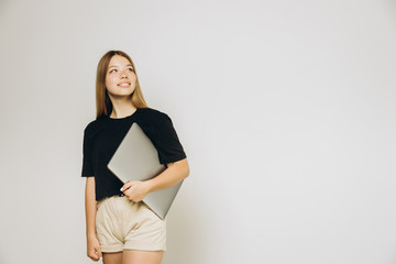 A teenage girl with a notebook against grey background