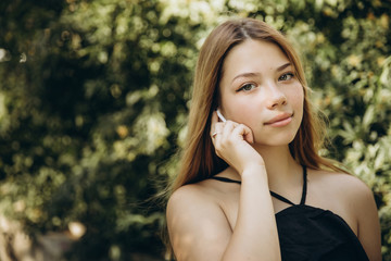 A teenage girl is using a mobile phone outdoors