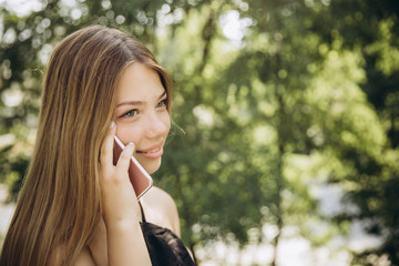 A teenage girl is using a mobile phone outdoors
