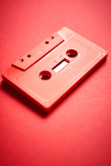 old red cassette tape on a minimalist background