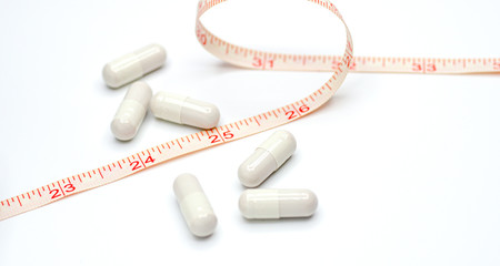 Measuring tape and pills for dieting concept. medical health care and prevention. Diet pills and measuring tape.