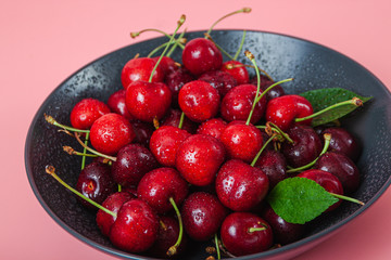 Cherry with leaf on plate and water dropsand on grey stone table