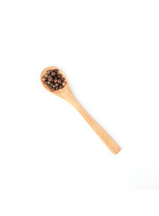 Wooden spoon and black pepper isolated