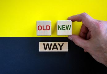 Businessman holds a cubes with word 'new'. Wooden cubes with  words 'old way'. Beautiful yellow and...