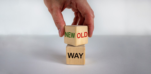 Male hand flips wood cube with 'new way' or 'old way' words on beautiful white background, mail...