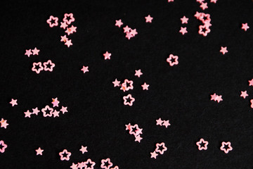 pink stars on black background close up