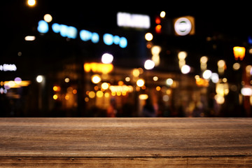 background Image of wooden table in front of abstract blurred restaurant lights