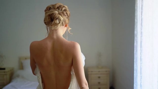 rear view. the beautiful blonde bride wears a gown.