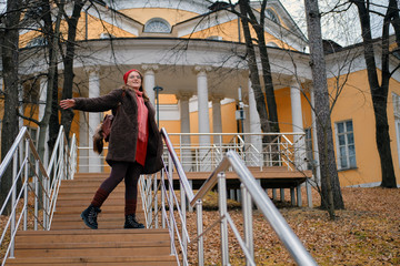 Obraz na płótnie Canvas Young woman on the background of a historic building in an autumn park