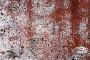 
Wall texture painted with white and red paint. Very damaged street wall.