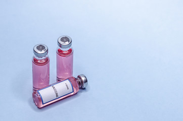 Vaccine in glass bottles on a white background. Three vials with one dose of vaccine.