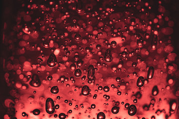 Bubbles of different shapes in red color, water droplets and abstract background. Bubbles pattern and illumination