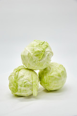 Fototapeta premium Fresh cabbage three pieces lie on top of each other, isolated on a white background. Vertical photo