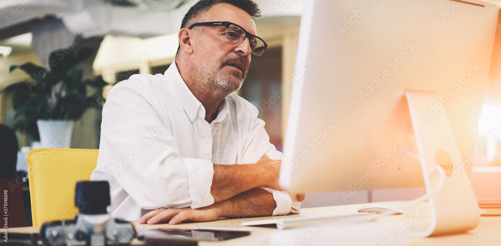 Aufkleber nature handsome man in optical eyeglasses with black frame watching interesting video on website on 