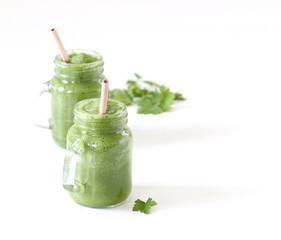 Green smoothie with parsley and spinach with a bamboo straw on a light background copy space 