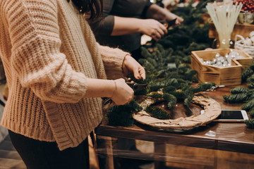 Woman making christmas wreath. A Christmas wreath made with your own hands.