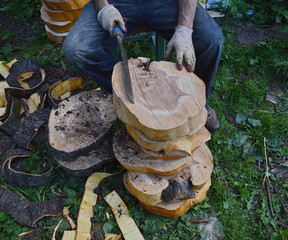 A man sitting in a garden, doing woodwork, a stack of timber, a cutting tool in his hand - Powered by Adobe