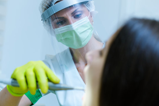 Female Dentist With Face Mask And Visor As Coronavirus Safety Precaution Checkup Dental Health Of Young Woman