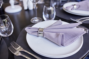 Wedding table set for dinner. Beautiful table setting with cutlery, purple napkin and plate. Top view. 