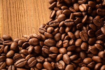 The background is covered with whole grains of coffee. There is an empty space in the upper left corner