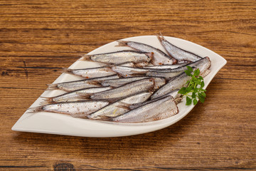 Anchovies in the bowl served basil leaves