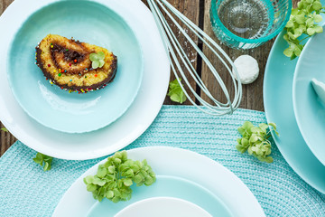 Light mint and white colored tableware set:  serving plates, bowls,  on wooden table. Crockery, dish, utensils and other different white and mint stuff on wooden table. Kitchen still life Top view