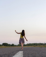 Fototapeta premium The girl leaves on the road barefoot