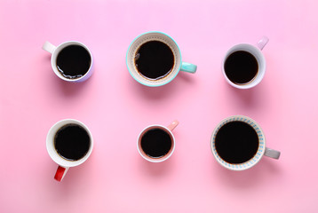 Group of different cups of coffee on pink background. Top view,flat lay,copy space.