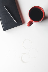 Blank organizer with pen and empty and full red coffee cups. Isolated on white background