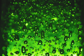 Bubbles of different shapes in green color, water droplets and abstract background. Bubbles pattern and illumination