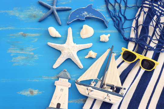 wooden vintage boat, dolphin, towel, boat and sea shells over blue background