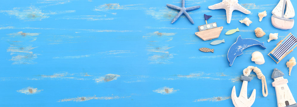 wooden vintage boat, dolphin, boat and sea shells over blue background