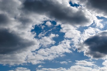 Fototapeta na wymiar storm clouds on blue sky with fluffy clouds