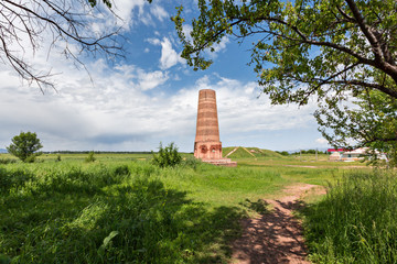 Fototapeta na wymiar Burana tower, tall and large minaret in the ruins of the ancient site of Balasagun, in Kyrgyzstan.