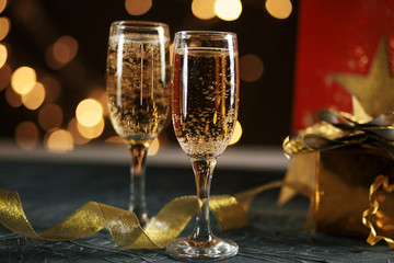Ribbon, baubles and wine against Christmas lights.