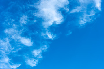 Fototapeta na wymiar Blue sky with white curly clouds