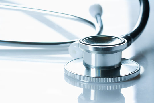 Stethoscope On Glossy White Table, The Black Phonendoscope, Close Up On White Background,