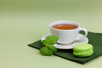 Green tea, mint macaroni with mint on the green paper background. Copy space