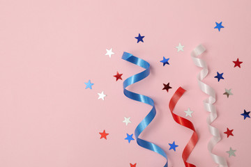 White, red and blue curly ribbons and stars on pink background