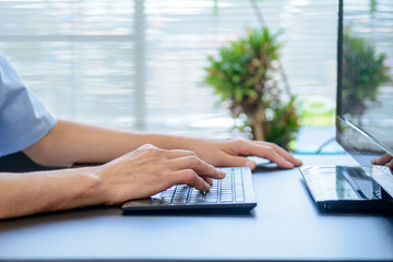 パソコンのキーボードを打つ男性の手