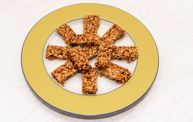 Homemade oat and peanut protein bars on a yellow serving plate, the image has some room for text.