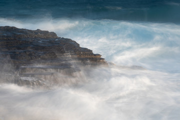 Splashing stormy windy sea waves on a rocky seashore