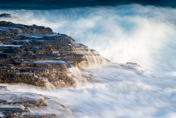 Splashing stormy windy sea waves on a rocky seashore