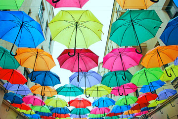 Fototapeta na wymiar Colored umbrellas hanging at the top. Local landmark