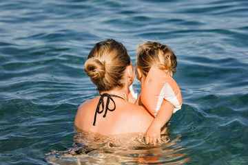 Mother playing with daughter in sea