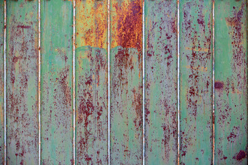 Old rusty metal fence. Green paint will peel off the fence. Close-up. background. copy space