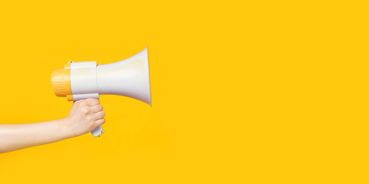 Woman's hand holding a megaphone, copy space.