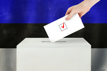 Estonian Vote concept. Voter hand holding ballot paper for election vote on polling station
