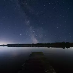 Fotobehang night sky over lake with litle pier © EvhKorn